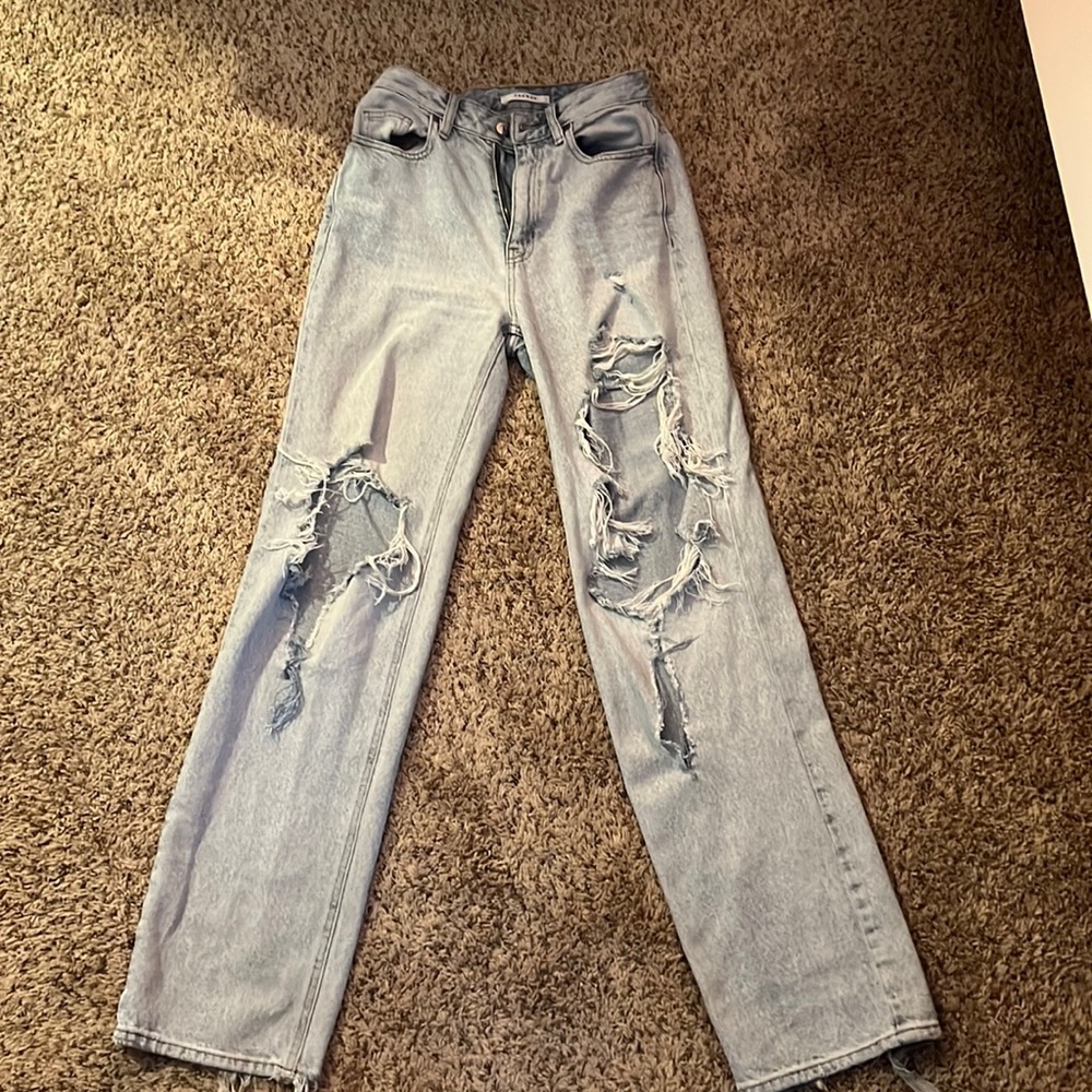 blue, mom-style jeans with large rips at the front